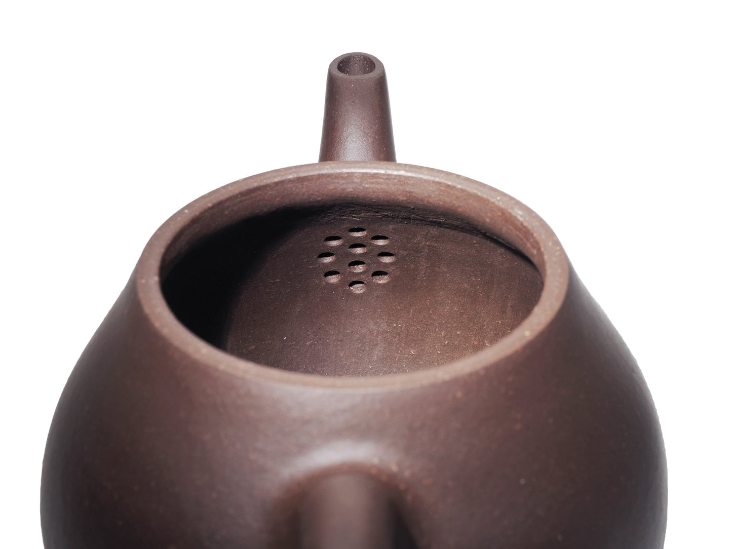 Interior view of the Da Ming Yuan Luo Han teapot showing the multi‑hole filter used to strain tea leaves.