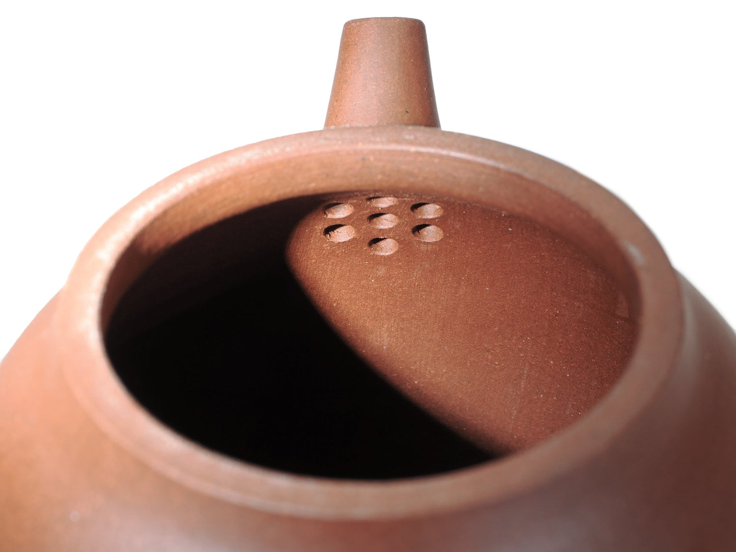 Close‑up of the interior of the Hong Pi Long Da Long Dan teapot showing the built‑in multi‑hole filter near the spout for smooth pouring.