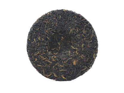 Unwrapped Dianhong cake back showing center dimple