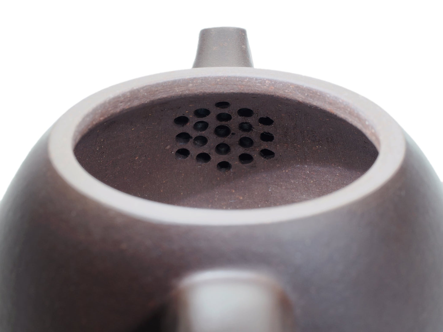 Close‑up of the Da Long Dan teapot’s interior with a built‑in multi‑hole filter near the spout for smooth, even pouring.