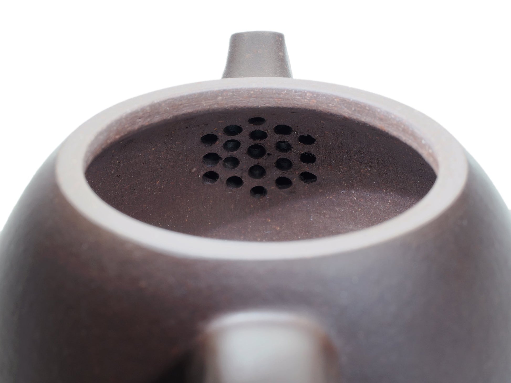 Close‑up of the Da Long Dan teapot’s interior with a built‑in multi‑hole filter near the spout for smooth, even pouring.