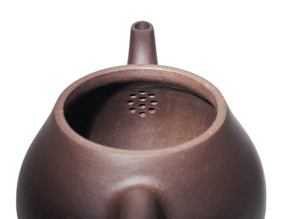 Interior view of the Da Ming Yuan Luo Han teapot showing the multi‑hole filter used to strain tea leaves.