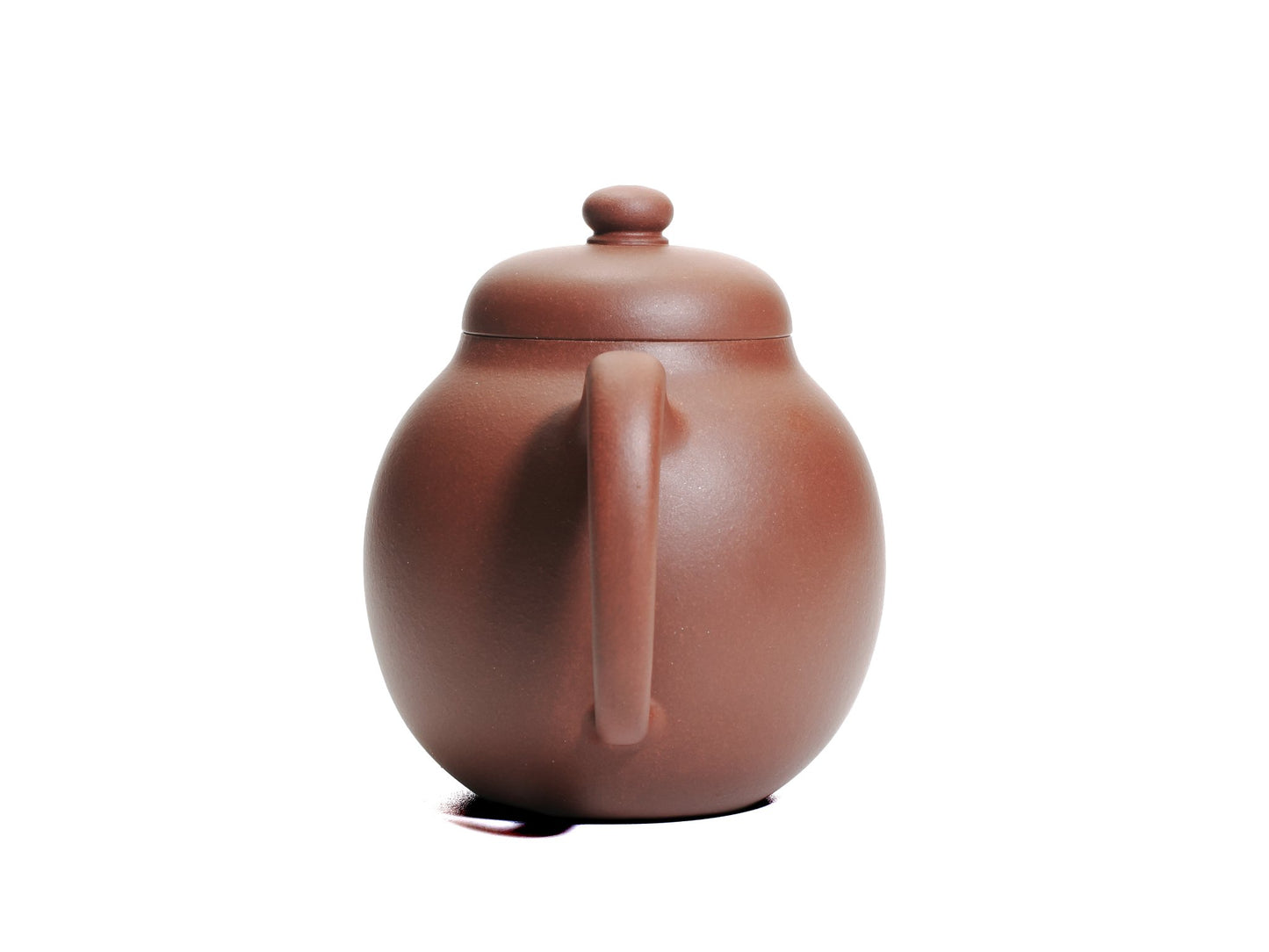 Back view of the Da Long Dan teapot focusing on the rounded handle and smooth red clay surface.