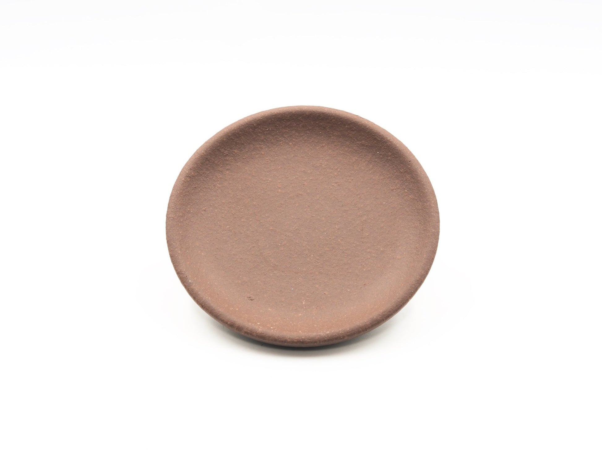 Angled view of round Dehou-style tea coaster in Lao Zini clay
