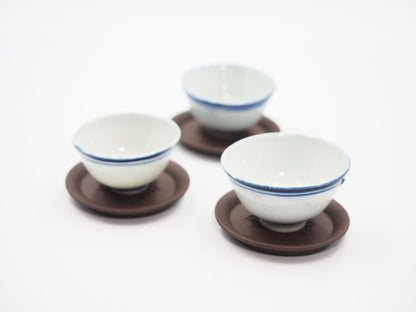 Yixing tea coasters with blue-rimmed porcelain teacups for Gongfu tea setup