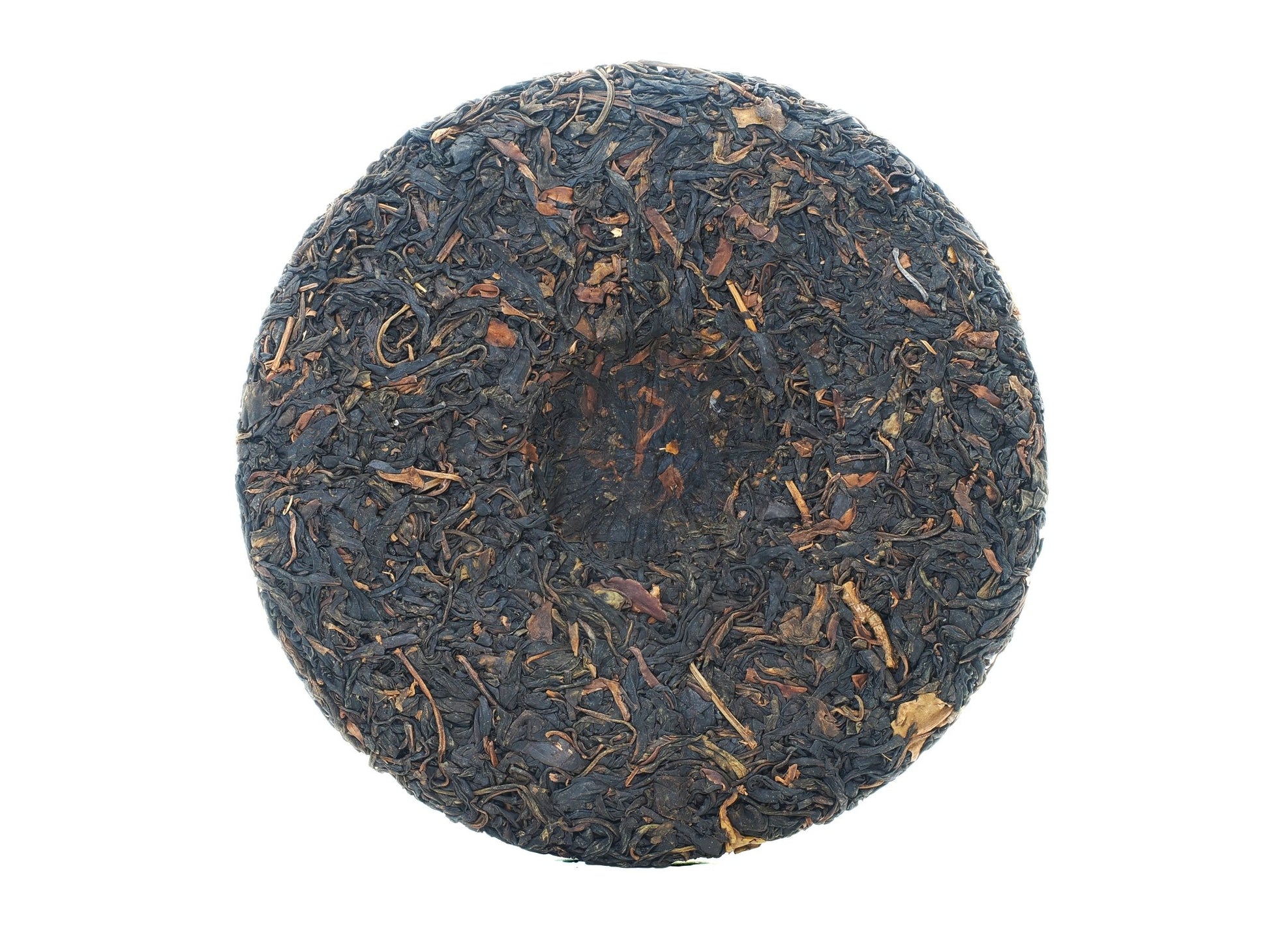 Back view of the unwrapped 2008 Wuliang Gushu Pu-erh Tea Cake showing pressed tea leaf surface
