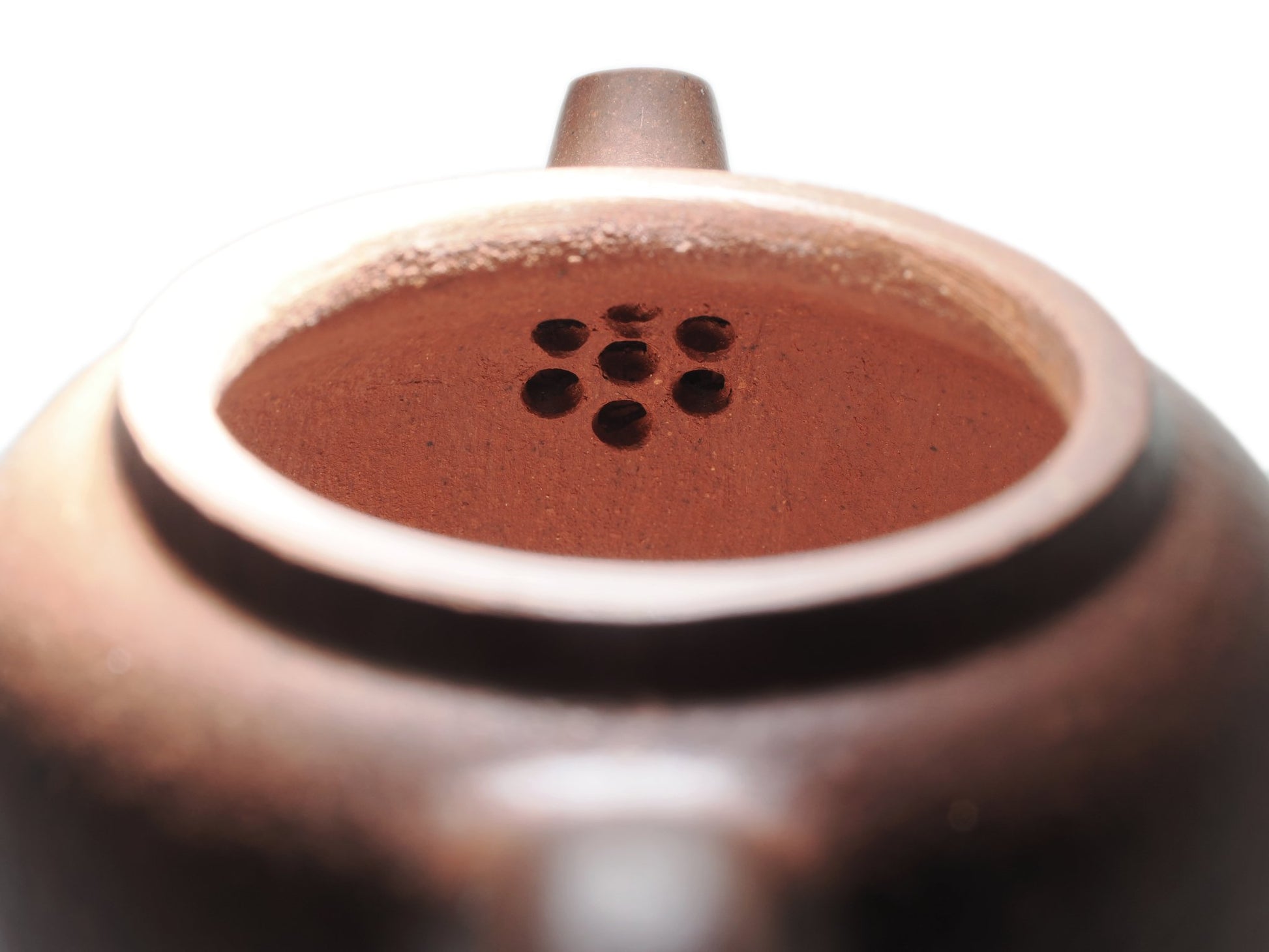 Close‑up of the multi‑hole built‑in filter inside the Xiao Da Bin Yixing teapot, carved from diamond‑grade purple clay.