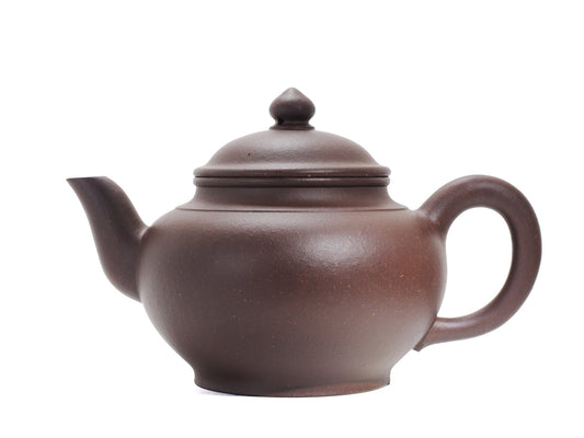 Side view from the opposite side of the Xiao Ying teapot showing the long curved spout, rounded body and ergonomic handle.