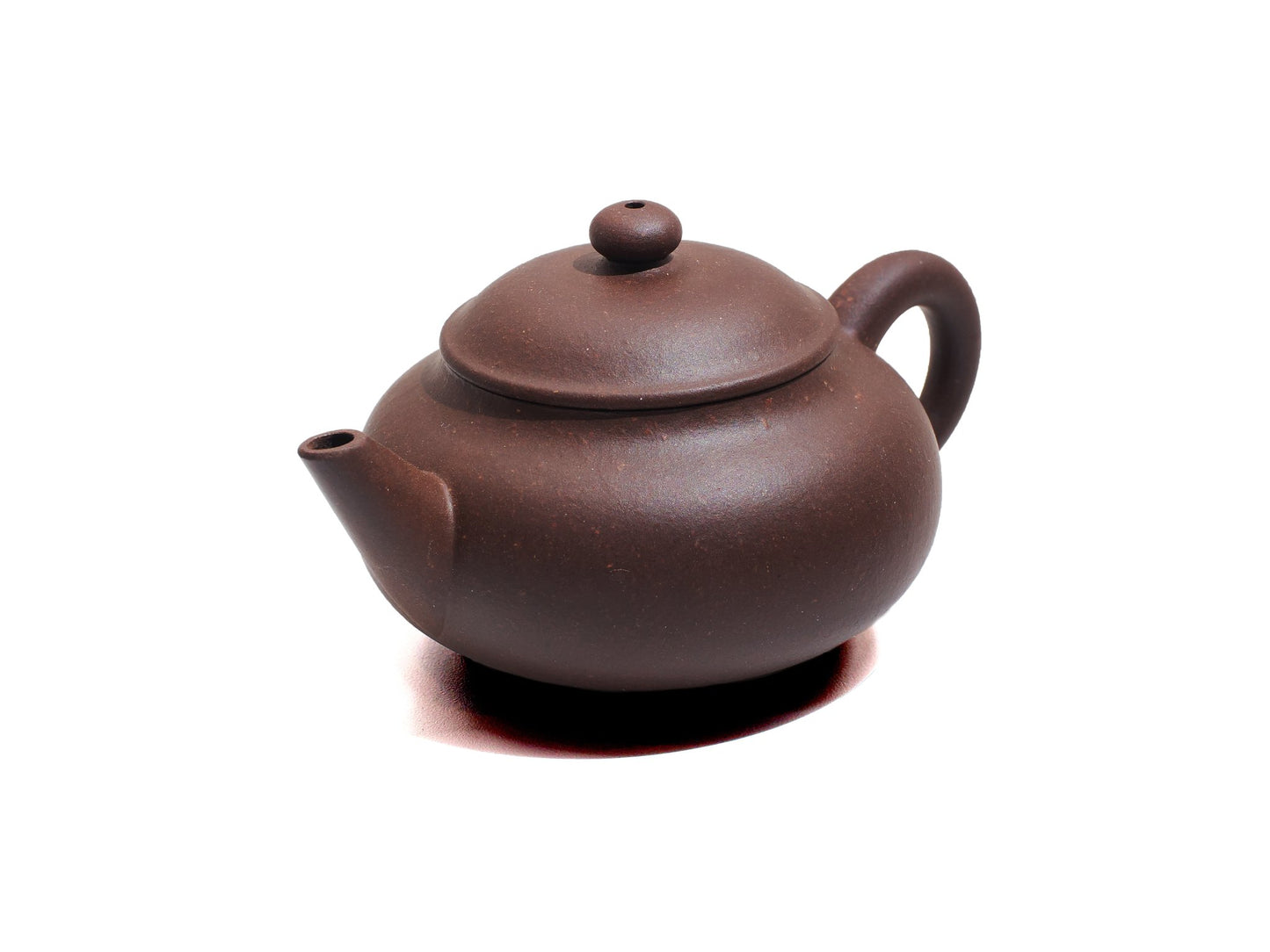 Angled view of Cha Zhi Ji Junde Yixing teapot in bronze grade purple clay